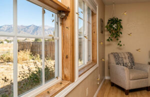 Bees flying around a living room window with mountains in the background.